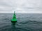 Green Navigational buoy in sea with clouds slow motion