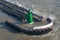 Green navigational light on a breakwater at a port