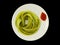 Green noodles on a plate with tomato sauce- isolated