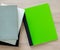 Green notebook and well worn books on a wooden desk