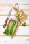 Green okra pods on cutting board with a knife. on white table