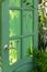 Green old door on backyard, leading nowhere. Decorative element. Using outdated things in a new quality