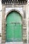 Green old door and traditional moroccan tiles on old stone house in Essaouira, Morocco