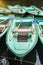 Green old empty boats with wooden oars on the lake closeup