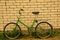 Green old retro Russian folding bicycle on a background of white bricks
