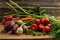 Green onions, garlic, carrots, beet and tomatoes against the background of old grey boards