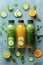 Green and orange juice bottles with cucumber slices and mint on a blue textured background.