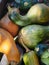 green and orange pumpkins of different shapes, bottle lie in a heap in the garden. In a dark tone. Thanksgiving concept