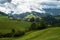 Green organic countryside farms and meadows in julian alps with mountains landscape