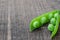Green organic peas on wooden background