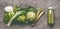 Green organic vegetables smoothie with chard, fennel, artichokes and rhubarb in bottle on gray granite table , top view.