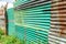 Green painted rusty corrugated iron fence