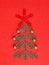 Green Paper clips Christmas tree and red star on red paper background.