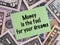 A Green paper note with words Money is the Fuel for Your Dreams on a dollar bills background