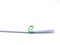 Green paperclip attached on white paper isolated