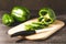 green paprika cut on a wooden board/Slicing peppers on a wooden cutting board with knife on a dark wooden table, selective focus