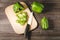 green paprika cut on a wooden board/ Slicing peppers on a wooden cutting board with knife on a dark wooden table. Top view