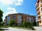 Green park with planter, flowers and trees and multi unit condominium building