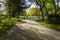 Green park with sunlight and paved path with bench to sit on. Burgos