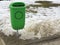Green pastic garbage bin or can on street