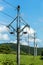 Green pasture, blue sky and power lines in the Czech countryside. Electricity distribution. Ecological energy