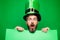 Green patricks background. Man in Saint Patrick`s Day leprechaun party hat having fun on green background. Copy space.