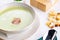 Green pea cream soup with bacon and cream in bowl with croutons.