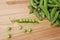 Green peas in pods freshly picked on wood.