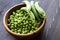 Green peas in a wooden bowl. Seasonal products. Vegetarianism. Close-up. Selective focus