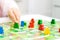 green people figure in hand of child. red, blue, green wood chips in children play - Board game and kids leisure concept.