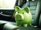 Green piggy bank in the car interior. The concept of purchasing, credit, leasing or car insurance