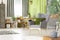 Green pillow on grey armchair in modern living room interior wit
