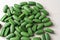 green pills chlorella on a gray background. nutritional supplements