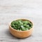 Green pills spirulina or chlorella seaweed in the wooden bowl. g