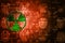 Green Pixelated Radiation icon on orange digital background with copy space. Science concept