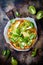 Green pizza with pesto, zucchini, tomatoes, avocado, jalapeno, mozzarella cheese and fresh basil.