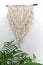 Green plant, knitted tapestries hanging on wall, bohemian interior decoration