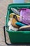 Green plastic box filled with a pile of old, colorful, worn out brushes for grooming horses - Vertical