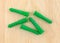 Green plastic drywall anchors on a pine board.