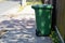 Green plastic garbage can or trash disposal bin on wheels