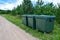 Green plastic garbage containers installed along the road in a modern European village. The concept of separate garbage collection