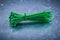 Green plastic self-locking cable ties on metallic background con