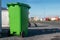 Green plastic wheelie bin in a street ready for collection, waste and recycle industry. Warm sunny day. Low angle of view,