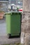Green plastic wheelie garbage bin out in a street ready for pick up by a waste management company
