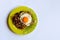 Green plate with fried egg and onion on a light background.