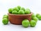 Green plums in a pottery bowl