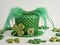 Green polka dot leprechaun hat with a gold sparkly buckle surrounded by glittery green four leaf clover shamrocks on a white