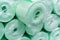 Green polyethylene foam backing. Insulation material in rolls on the counter in the store. Close-up