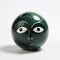 Green porcelain ball with a glazed design of a friendly face. Minimalist abstract art. Generative AI