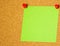 Green post-it on a coarkboard background